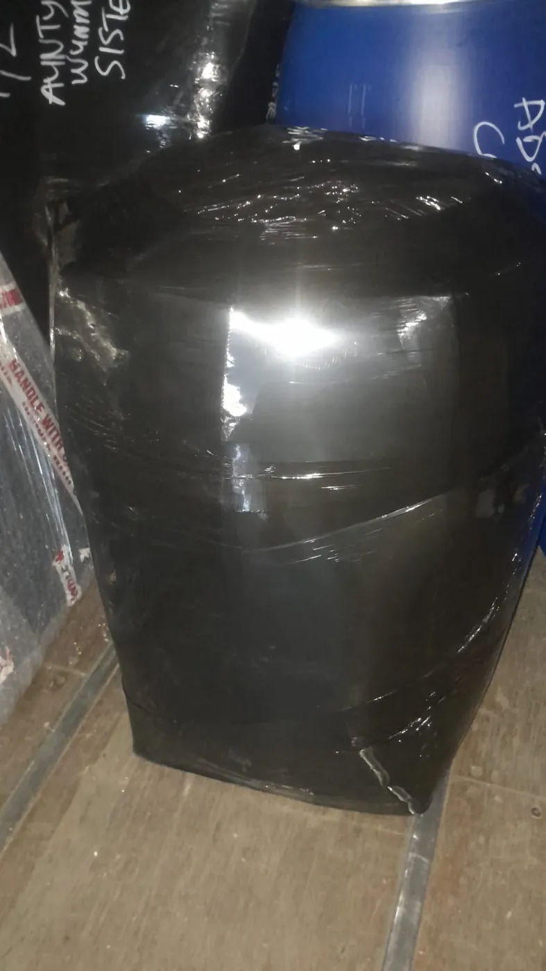 Packed barrel fully wrapped in black protective film inside the container