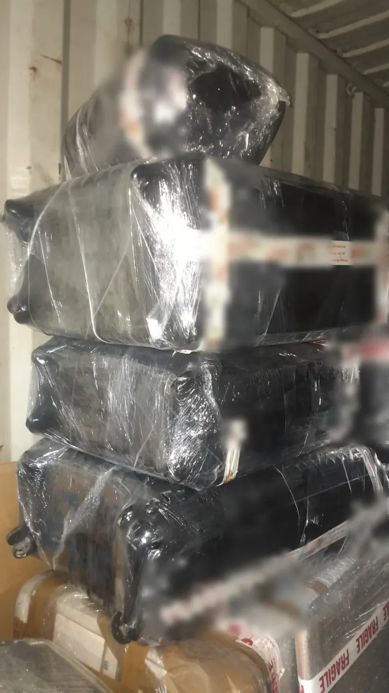 Wrapped consignments stacked inside a shipping container