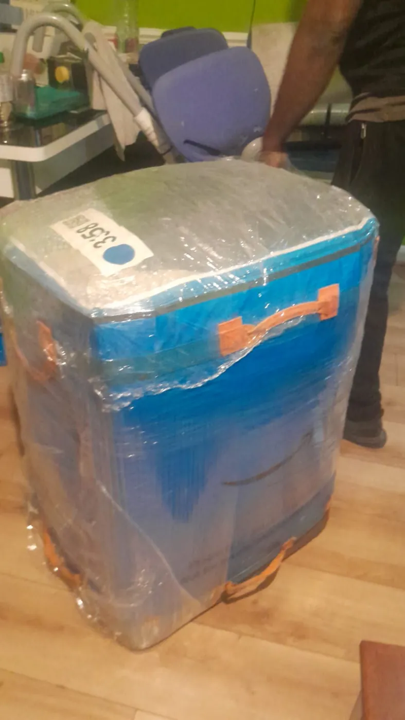 Cargo bag fully wrapped in protective film with taped handles