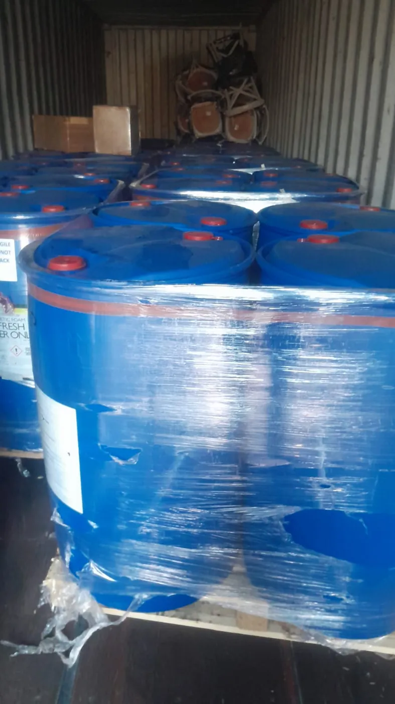 Rows of palletised drums shrink-wrapped inside a shipping container